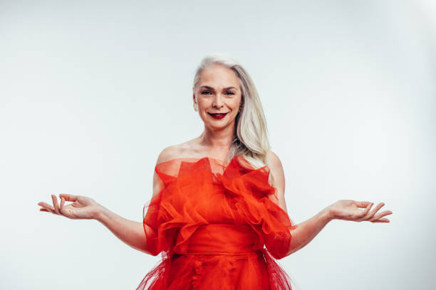 Stylish woman with grey hair and blue eyes wearing a vibrant red dress