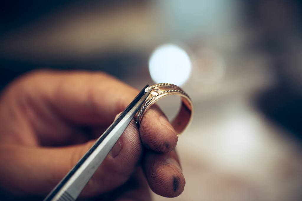 Close up of cubic zirconia on a sterling silver ring being polished with a soft-bristled brush
